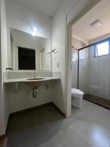 a bathroom with a sink and a shower and a toilet at Hotel Nações Plaza in Bauru