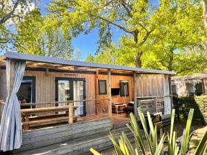drewniany domek z tarasem i patio w obiekcie Mobilhome Camping Biscarrosse 5 étoiles bord du lac w mieście Biscarrosse