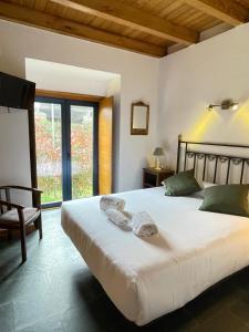 a bedroom with a bed with towels on it at A Ribeira do Tambre in Troitosende +52 photos