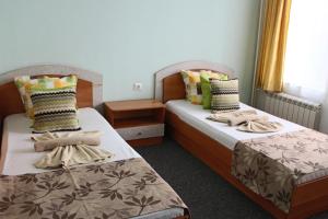 two beds in a hotel room withskirts at Guest House Elit in Burgas