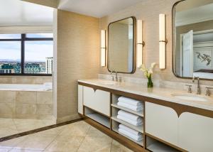 a bathroom with two sinks and a tub and a mirror at The Ritz-Carlton, Denver in Denver
