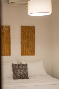een slaapkamer met een bed met twee schilderijen aan de muur bij Houseloft Cosmopolitan Comfort in Thessaloniki