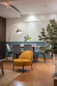 een eetkamer met een gele stoel en een tafel bij Houseloft Cosmopolitan Comfort in Thessaloniki