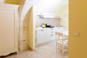 a kitchen with white cabinets and a table in it at La Perla del Mare in Monopoli +80 photos