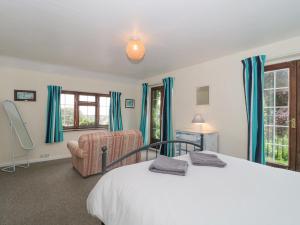 a bedroom with a bed and a chair at The Cottage in Watchet