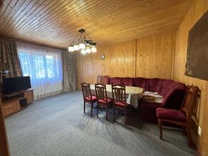 a living room with a couch and a table and chairs at САДИБА та ЧАН "NA PAGORBI" in Yaremche