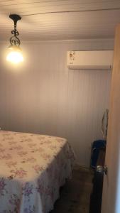 a room with a bed and a light on a wall at La Cabaña Punta Negra in Punta Colorada