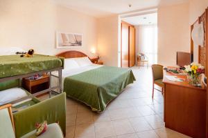 Pokój hotelowy z łóżkiem i biurkiem w obiekcie Hotel Gabriella w mieście Diano Marina