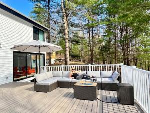 une femme assise sur un canapé sur une terrasse dans l'établissement Brand New House with Huge Patio, à Kerhonkson