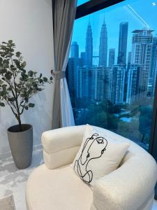 a white couch with a drawing on it in front of a window at Eaton Residences KLCC by Ikon in Kuala Lumpur