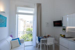 a white kitchen with a white couch and a table at Residenza Ottaviano Boutique Apartments in Sperlonga