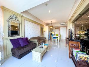 sala de estar con sofá y mesa en Trillium Apartment - Cozy and Bright Downtown Surabaya by Le Ciel Hospitality en Surabaya