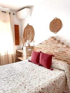 a bedroom with a large bed with red pillows at Casa Rural Pernales II in Ruidera
