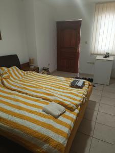 a bed with a striped blanket and a book on it at Vila Jovana in Rogljevo +12 photos