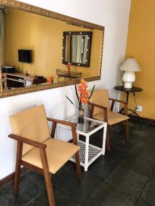 Habitación con 2 sillas y mesa con espejo. en Pousada Casa Hospedaria, en Paraty