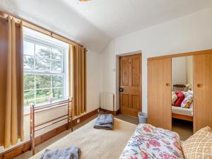 um quarto com uma cama e uma janela em Porthysgaden em Twdweiliog