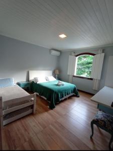 Un dormitorio con una cama verde y una ventana en Pousada Casa Hospedaria, en Paraty