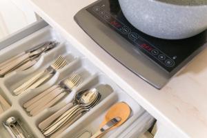 a drawer filled with silver utensils and a sink at La Perla del Mare in Monopoli