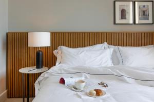 Una cama con una taza de café y un plato de comida. en Hotel Casa Lucia en Buenos Aires