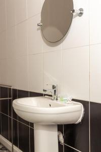 uma casa de banho com um lavatório branco e um espelho. em Lovely Suite 1 - Private Room in Eccles em Manchester