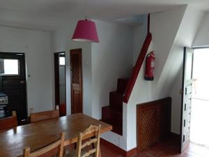 a dining room with a table and a red lamp at Refúgio da Montanha in Sobral +3 photos
