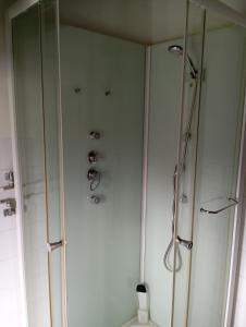 a bathroom with a shower and a toilet and a glass shower stall at Refúgio da Montanha in Sobral