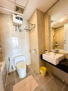 a bathroom with a toilet and a sink at Trillium Apartment - Cozy and Bright Downtown Surabaya by Le Ciel Hospitality in Surabaya