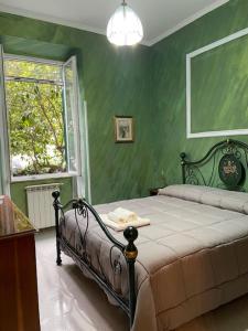 a bedroom with a bed with green walls and a window at Roma centrale 5 minuti dalla metropolitana in Rome