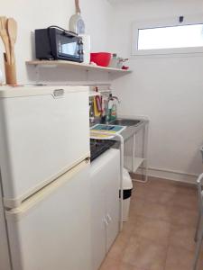 La cuisine est équipée d'un réfrigérateur blanc et d'un évier. dans l'établissement One bedroom apartement with wifi at Taranto, à Tarente