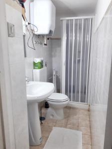 La salle de bains blanche est pourvue de toilettes et d'un lavabo. dans l'établissement One bedroom apartement with wifi at Taranto, à Tarente