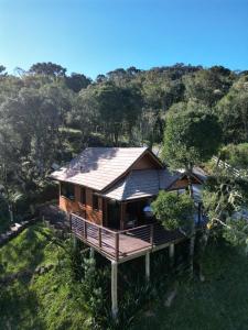 a wooden house with a roof on a hill at Vallée Cabanas in Urubici