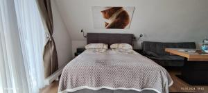 a bedroom with a bed and a chair and a table at Schicke Ferien Wohnung mit tollem Ausblick in Schwarzwald. in Villingen-Schwenningen