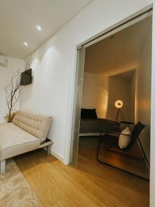 a living room with a couch and a bed at Refúgio da Rainha in Moledo
