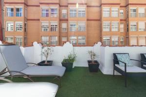 a balcony with chairs and a fence and a building at My Loft 4 You Sorolla in Valencia