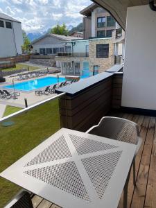 uma varanda com mesa e cadeiras e uma piscina em Spa Apartments - Zell am See em Zell am See