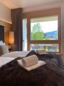 a bedroom with a large bed with a large window at Spa Apartments - Zell am See in Zell am See