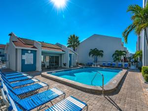 basen z niebieskimi leżakami obok budynku w obiekcie Madeira Beach Yacht Club 343h w St Pete Beach