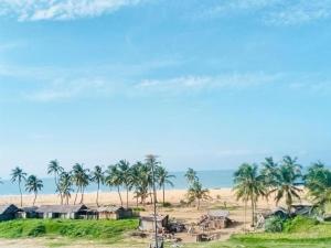 uma vista para uma praia com palmeiras e casas em Villa luxueuse - front de mer - vue sur la mer em Cotonou