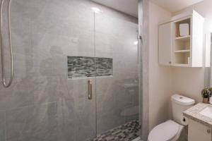 La salle de bains est pourvue d'une douche avec une porte en verre. dans l'établissement Deluxe Designer Retreat at Boca-Chica near SpaceX, à Brownsville