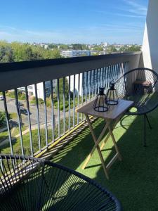 een tafel en stoelen op een balkon met uitzicht op een straat bij Appartement Spacieux - 10' Gare in Angers