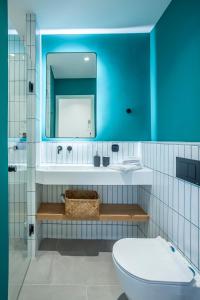 een badkamer met een wastafel, een spiegel en een toilet bij Mazi Rooms Charilaou 2,3 in Thessaloniki