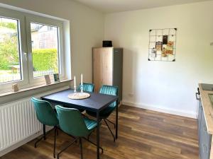 una sala da pranzo con un tavolo e sedie verdi di Ferienwohnung an der Eisdiele a Freisen