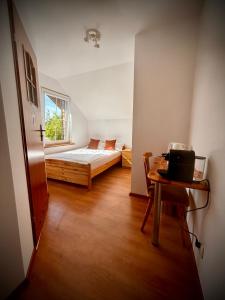 a bedroom with a bed and a table with a laptop at Pokoje Kasztanowa in Wilkasy