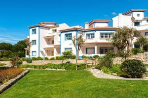 a large white house with a yard at Praia del Rey Golf & Beach Resort - T3 in Amoreira