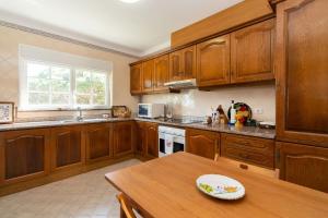 a kitchen with wooden cabinets and a wooden table at Praia del Rey Golf & Beach Resort - T3 in Amoreira