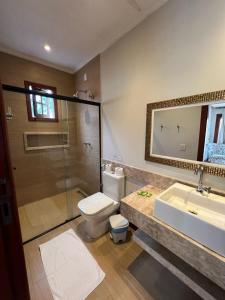 uma casa de banho com um WC, um lavatório e um chuveiro em Pousada Casa Hospedaria em Paraty