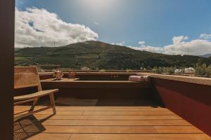 uma varanda com uma cadeira e vista para uma montanha em Torel Quinta da Vacaria - Douro Valley em Peso da Régua