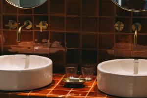 Baño con 2 lavabos y 2 vasos en una encimera en Torel Quinta da Vacaria - Douro Valley en Peso da Régua