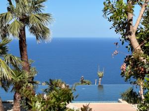 a view of the ocean from a resort with palm trees at Baglio La Porta by Geocharme in San Vito lo Capo