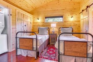 two beds in a room with wooden walls at Mountain Home Cabin Rental with Fire Pit! in Mountain Home